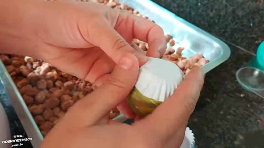 Colocando forminha de docinho no ovo colorido com amendoim.